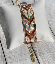 a white pillow with a chain attached to it on a wooden table next to a key