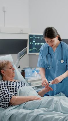 two women in hospital gowns are looking at something on the bed while an older woman stands next to her