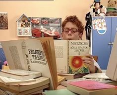 a woman sitting at a desk with lots of books