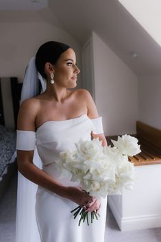 a woman in a wedding dress holding a bouquet of flowers