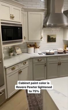 an image of a kitchen with white cabinets and silver appliances in the middle of it