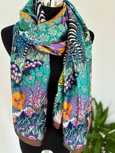 Size: 189*90cm Add a splash of vibrant jungle flair to your wardrobe with this multicolor soft polyester silk scarf. Designed to capture the lush beauty of tropical foliage, this scarf features an array of vivid hues that will brighten up any outfit. Made from high-quality polyester silk, it offers a luxurious feel and a soft touch, ensuring maximum comfort throughout the day. Lightweight and versatile, it's perfect for draping over your shoulders or tying around your neck in various styles. Whe Bohemian Multicolor Scarves With Abstract Print, Bohemian Multicolor Scarf With Abstract Print, Multicolor Floral Print Shawl For Summer, Multicolor Silk Floral Print Shawl, Multicolor Silk Shawl With Floral Print, Multicolor Floral Print Scarf For Beach, Multicolor Floral Print Beach Scarf, Multicolor Silk Scarf For Beach, Green Bohemian Silk Scarf With Floral Print