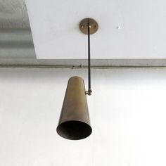 a light fixture hanging from the ceiling in a room with white walls and flooring