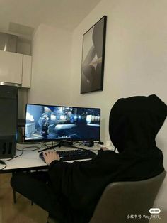 a person sitting at a desk in front of a computer monitor with a keyboard and mouse