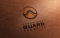 the beach life guard security logo is shown on a brown leather surface with gold accents