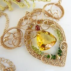 "The lemon quartz at the center of this necklace is bright, reminiscent of a midday sun. It isn't strictly a lemon quartz: there are little hints of orange to it. It glows rather magnificently. An exquisite frame of 14k gold fill wire has been constructed aroun the stone with complex swirls. A layer of chrome diopside, peridot, and tourmaline wraps around the inside and some madeira citrine accents the top of the stone. The pendant is about 2.5\" long by 3\" wide and the double layer chain is ad Fine Green Citrine Jewelry, Yellow Peridot Jewelry For May Birthstone, Citrine Gemstone Jewelry For May Birthstone, Yellow May Birthstone Jewelry, Green Citrine Jewelry Gift, Yellow Peridot Jewelry Gift, Green Citrine Jewelry For Gifts, Elegant Citrine Wire Wrapped Jewelry, Yellow Multi-stone Fine Jewelry