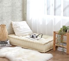 a living room with white fur rugs and wooden furniture in front of a brick wall