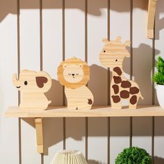 three wooden toy animals sitting on top of a shelf