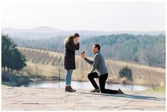 a man kneeling down next to a woman who is holding a wine glass in her hand