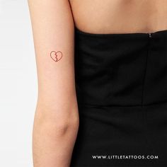 a woman with a small heart tattoo on her arm