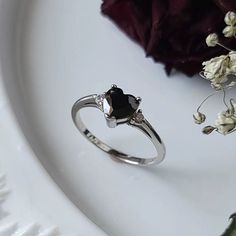 A gorgeous black onyx heart ring. Made with sterling silver and cubic zirconia gems. Multiple sizes available. Black Heart-shaped Diamond Jewelry, Black Diamond Heart-shaped Jewelry, Black Ring With Center Stone As Gift, Black Ring With Center Stone Gift, Black Promise Ring With Center Stone, Anniversary Rings With Diamond Accents And Black Spinel, Anniversary Black Spinel Rings With Diamond Accents, Black Sterling Silver Rings With Accent Stones, Sterling Silver Black Rings With Accent Stones