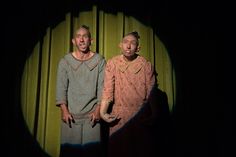 two men standing in front of a green curtain