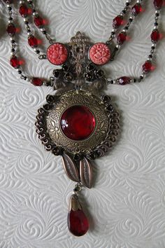 "This listing is for An Art Nouveau Antique 1930's Czech Vibrant Red Color Glass bead, and delicately carved celluloid Festoon Lariat Necklace and Earring Set* A true One of a kind set! The pieces show the patina of time, which makes this a testimonial of a past era. Glamorous and classic chic. Here are the details of this specific gem exactly as shown on pictures: kindly regard that this piece does show wear on the largest glass centerpiece, but otherwise all else is in superb pre_loved conditi Collectible Red Filigree Jewelry, Red Antique Collectible Jewelry, Red Filigree Vintage Jewelry, Red Vintage Filigree Necklace, Vintage Red Round Jewelry, Red Bohemian Filigree Jewelry, Red Bohemian Jewelry With Intricate Design, Bohemian Red Filigree Jewelry, Victorian Red Jewelry With Vintage Charm