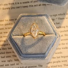 an engagement ring is sitting on top of a book