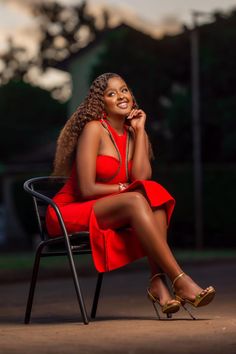 a woman in a red dress sitting on a chair