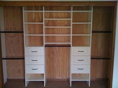 an empty closet with two white drawers and three open shelving units on the wall