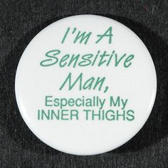 a white button with green writing that says i'm a sensitive man especially my inner thighs