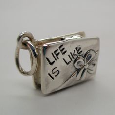 "This three-dimensional, moveable, antiqued sterling silver Box Of Chocolates charm is minted with the phrase \"Life is like\" on the front, and the phrase \"A box of chocolates\" on the reverse. The box opens to reveal two pieces of chocolate, one round and one square. Made by Brown County Silver. Vintage but in brand new, never worn condition. Length 5/8\" length Weight 4.9 grams See more @ https://www.etsy.com/shop/brocosi" Unique Silver Charms For Gifts, Antique Silver Sterling Silver Charms For Gifts, Meaningful Silver Rectangular Jewelry, Novelty Metal Charm Bracelet As Gift, Antique Silver Metal Charm Bracelet Gift, Silver Vintage Charm Bracelet As Gift, Vintage Sterling Silver Charms For Gifts, Silver Charm Bracelet With Vintage Charm As A Gift, Spiritual Silver Charms For Gifts