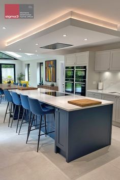 a large kitchen with an island and blue chairs