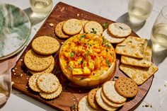 a wooden platter filled with crackers and dip