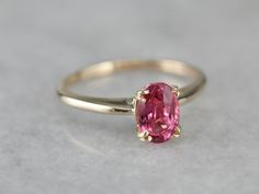 Truly all about the stone, this traditional, yellow gold mounting frames the stone perfectly while holding it securely with four split prongs. The center pops with an amazing pink color and is adorned with an expertly cut pink sapphire. Metal: 14K Yellow Gold Gem: Pink Sapphire 1.17 Carats Gem Measurements: 5 x 7.5 mm, Oval Ring Size: 5.75 Marks: "14" Stamped on the inside band Formal Pink Ruby Ring With Brilliant Cut, Formal Pink Brilliant Cut Ruby Ring, Classic Pink Ruby Ring With Accent Stones, Classic Pink Ruby Ring With Center Stone, Pink Round Cut Rings With Prong Setting, Pink Prong Setting Round Cut Rings, Pink Brilliant Cut Round Ruby Ring, Pink Brilliant Cut Ruby Ring, Formal Oval Pink Sapphire Ring