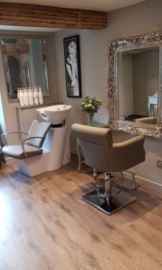 a hair salon with chairs and mirrors in the corner, one chair is up against the wall