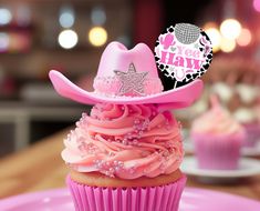 a cupcake with pink frosting and a cowboy's hat topper on it