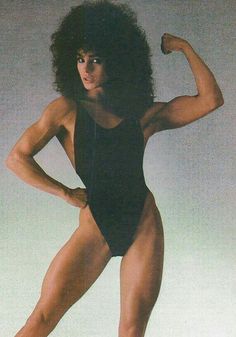 a woman in a bodysuit flexing her muscles with one hand on her hip