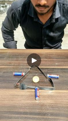 a man standing over a wooden table with tools on it