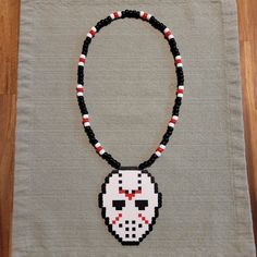 a beaded necklace with a skull on it is sitting on a piece of cloth