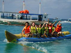 a group of people riding on top of a raft in the ocean