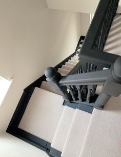 an overhead view of stairs and railings in a home with carpeted flooring