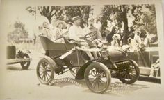 an old black and white photo of people riding in a car with two women on the back