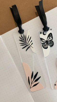 three bookmarks with black and white designs on them, one has a butterfly in the middle