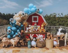 there are many farm animals and balloons on the table with it's own barn