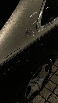 a close up of a parked car with raindrops on it