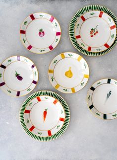 five plates with different designs and vegetables on them