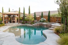 a backyard with a swimming pool and gazebo