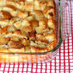 a casserole dish with bread in it on a red and white checkered tablecloth