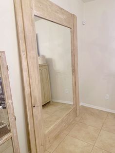 a large mirror sitting on top of a tiled floor