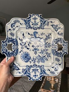 a person holding up a blue and white plate