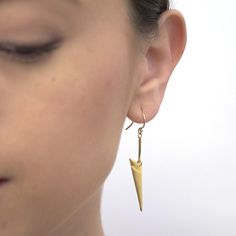 Close up side view of woman wearing pair of gold chevron shaped earrings on earwire. Modern Threader Earrings As A Gift, Modern Teardrop Plug Earrings As Gift, Modern Teardrop Plug Earrings For Gift, Modern Long Drop Earrings As Gift, Modern Long Drop Earrings For Gift, Modern Drop Earrings As A Gift, Modern Drop Earrings For Gift, Modern Single Drop Plug Earrings, Modern Teardrop Brass Linear Earrings