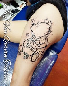 a woman's leg with a tattoo on it that has a drawing of a teddy bear holding a soccer ball