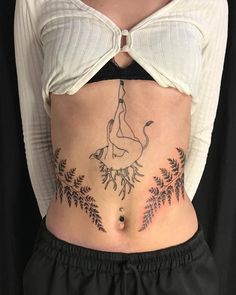 a woman's stomach with a tattoo on her belly and leaves around the waist