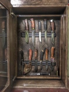 a wooden box filled with lots of different types of knives