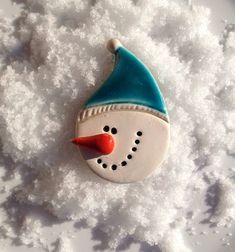 a snowman ornament sitting in the snow on top of some white snow