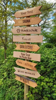 a wooden sign with many different signs on it's side in front of some trees