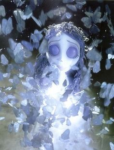 a creepy doll surrounded by butterflies floating in water with light shining on her face and eyes