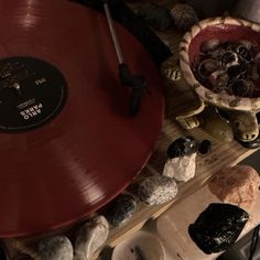 a record player sitting on top of a wooden table next to other records and bowls