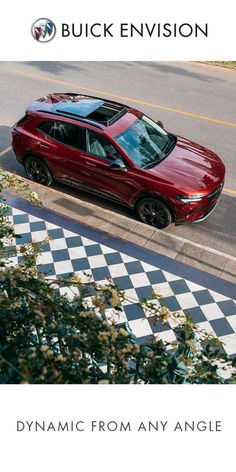 a red car parked on the side of a road next to a checkered sidewalk